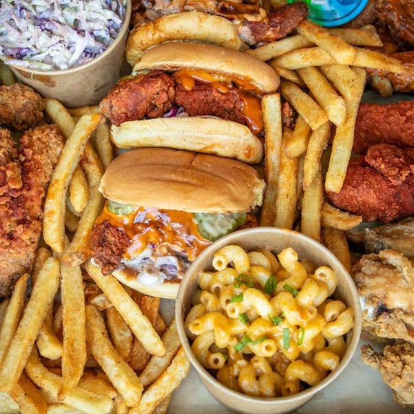 A Hot Birds fried chicken feast with sandwiches, fries, coleslaw, mac and cheese, and chicken pieces.