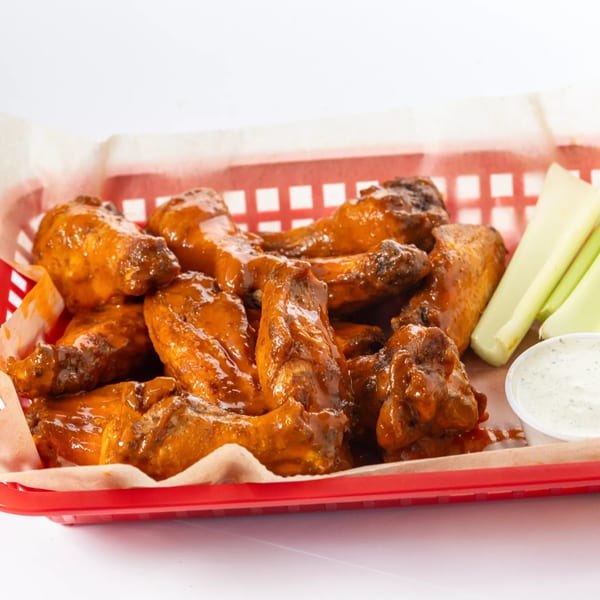 Hot Birds' fried chicken wings in a red basket with celery sticks and ranch dressing.