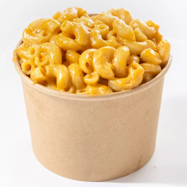 Creamy macaroni and cheese in a brown paper cup, a classic side dish from Hot Birds.